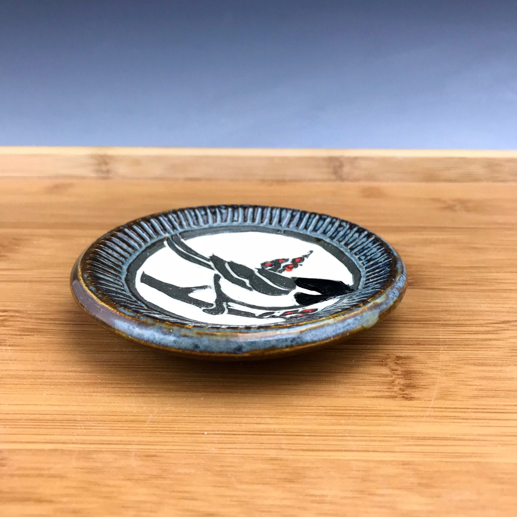 Small sgraffito pottery dish chickadee in gray glaze